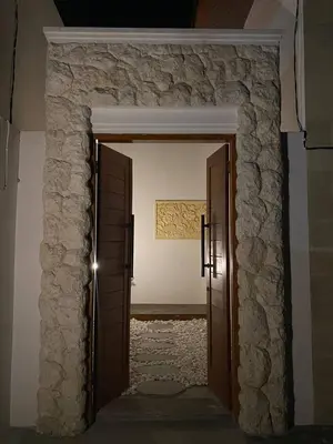 an open door into a room with a stone wall at Angeliq Villa Nusa Dua Bali in Nusa Dua