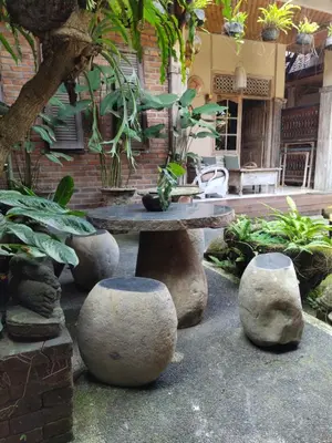 a patio with a stone table and some plants at Samblung Mas House in Denpasar