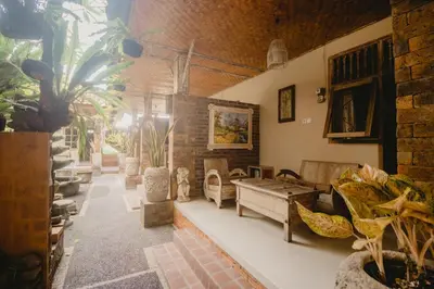 a living room with couches and chairs in a building at Samblung Mas House in Denpasar
