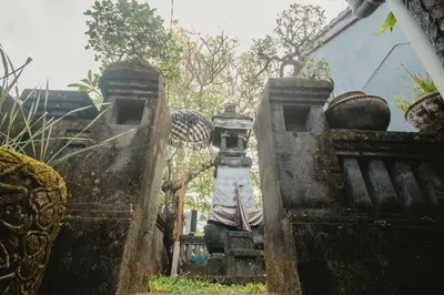 a person standing on a gate in front of a house at Samblung Mas House in Denpasar