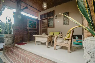a porch of a house with a table and chairs at Samblung Mas House in Denpasar