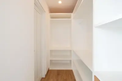 a walk in closet with white walls and wood floors at Villa Turkuaz in Seminyak