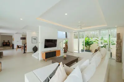 a living room with a white couch and a tv at Villa Turkuaz in Seminyak