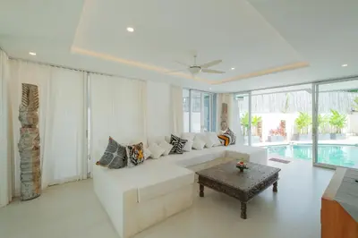 a living room with a white couch and a table at Villa Turkuaz in Seminyak
