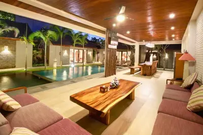 a living room with a pool in the background at Deanda Elegant 4 BR Private Pool Villa in Jimbaran