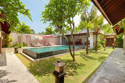 a backyard with a swimming pool and a house at Eksha Comfortable 3 BR Private Pool Villa in Jimbaran