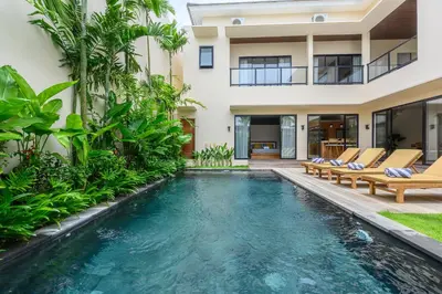 a swimming pool in the backyard of a house with a villa at Spacious 4BR Family Pool Villa in Sanur