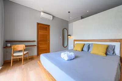 a bedroom with a blue bed and a chair at Spacious 4BR Family Pool Villa in Sanur