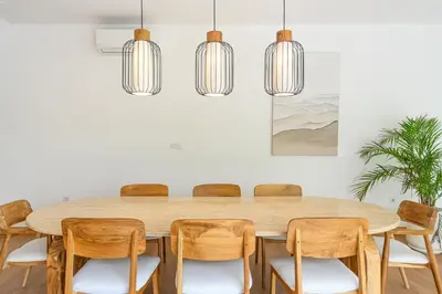 a dining room with a wooden table and chairs at Spacious 4BR Family Pool Villa in Sanur