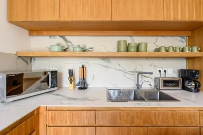 a kitchen with a sink and a microwave at Spacious 4BR Family Pool Villa in Sanur