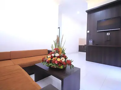 a living room with a couch and flowers on a table at Wisp Sunset in Legian