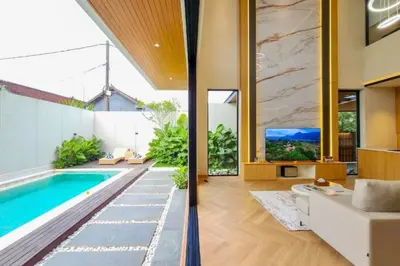 a living room with a pool and a tv at Foujina Elegant 4 BR Private Pool Villa in Jimbaran