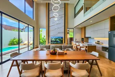 a kitchen and dining room with a large wooden table and chairs at Foujina Elegant 4 BR Private Pool Villa in Jimbaran