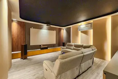a living room with a couch and a large screen at Foujina Elegant 4 BR Private Pool Villa in Jimbaran
