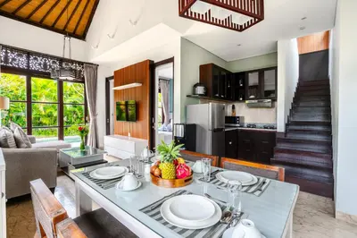 a kitchen and living room with a table and chairs at D'Maya Villa Jimbaran By Island Escape in Jimbaran