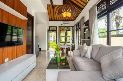 a living room with a couch and a tv at D'Maya Villa Jimbaran By Island Escape in Jimbaran