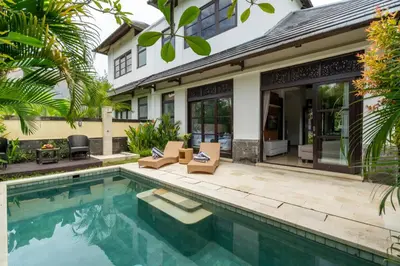 a swimming pool in front of a house at D'Maya Villa Jimbaran By Island Escape in Jimbaran
