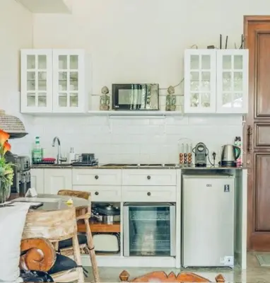 a kitchen with white cabinets and a stove top oven at Romantic getaway Seminyak in Seminyak