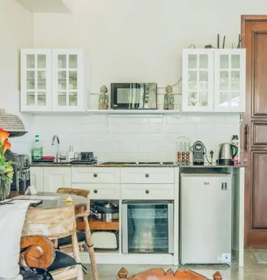 a kitchen with white cabinets and a stove top oven at Romantic getaway Seminyak in Seminyak