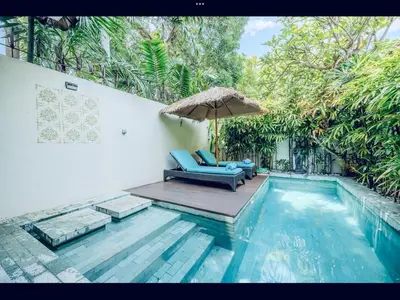 a swimming pool with a chair and an umbrella at Romantic getaway Seminyak in Seminyak