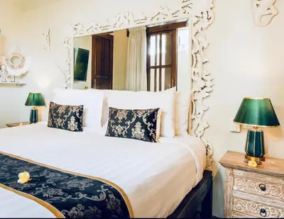 a bedroom with a large white bed with a mirror at Romantic getaway Seminyak in Seminyak