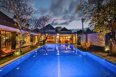 a swimming pool in front of a house at Ghania Peaceful 3 BR Private Pool Villa in Jimbaran