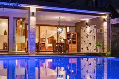 a swimming pool in front of a house at Ghania Peaceful 3 BR Private Pool Villa in Jimbaran