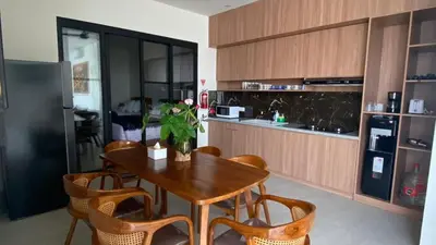 a kitchen with a wooden table with chairs and a refrigerator at Narayuka private villa in Seminyak