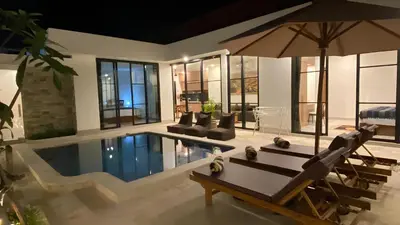 a house with a swimming pool and an umbrella at Narayuka private villa in Seminyak