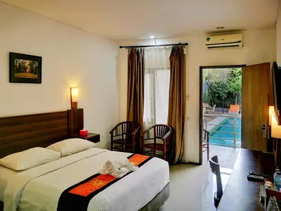 a hotel room with two beds with a stuffed animal on it at Dlima Hotel Villa in Legian