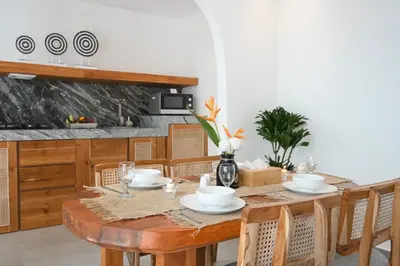 a wooden table with chairs and a dining room at The Wina Villa Canggu by The Wina Resorts in Canggu