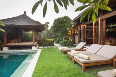 a backyard with a swimming pool and a villa at Villa Suar Drupadi in Seminyak