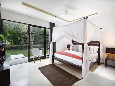 a bedroom with a bed with a canopy at Villa Mona in Canggu