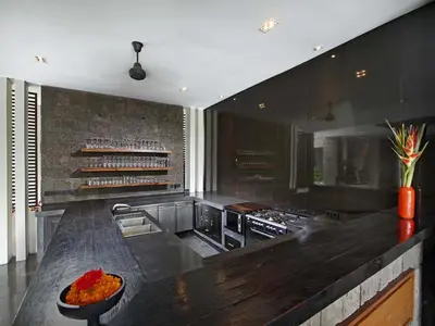 a kitchen with a black counter top and a stove at Villa Mona in Canggu