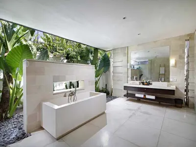 a bathroom with a tub and a sink and a mirror at Villa Mona in Canggu