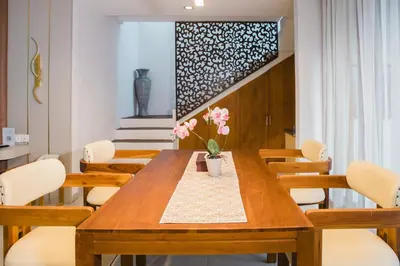 a dining room with a wooden table and chairs at Grand Kesambi Resort and Villas Seminyak in Seminyak