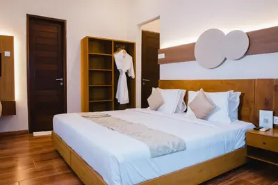 a bedroom with a large white bed and a closet at Grand Kesambi Resort and Villas Seminyak in Seminyak