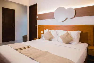 a bedroom with a large white bed with white pillows at Grand Kesambi Resort and Villas Seminyak in Seminyak