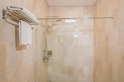a bathroom with a shower with a glass door at Grand Kesambi Resort and Villas Seminyak in Seminyak