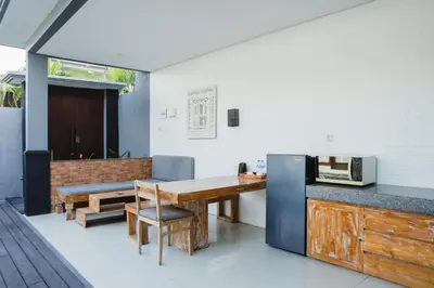 a kitchen with a wooden table and a microwave at Grand Kesambi Resort and Villas Seminyak in Seminyak