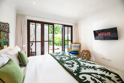 a bedroom with a bed and a view of a patio at Villa Atma 2BR Fully Equipped Kitchen in Seminyak