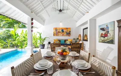 a dining room with a table and a swimming pool at Villa Atma 2BR Fully Equipped Kitchen in Seminyak