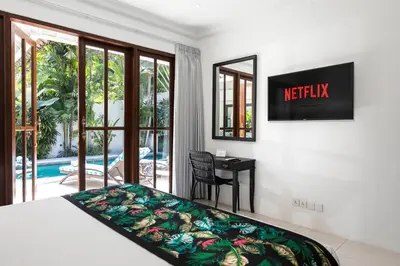 a bedroom with a bed and a view of a pool at Villa Merah in Seminyak