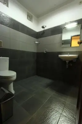 a bathroom with a toilet and a sink at De Dukuh Guest House in Kuta