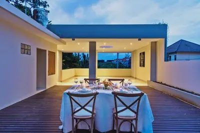 a dining table on the deck of a house at Desa Di Bali Villas in Kerobokan