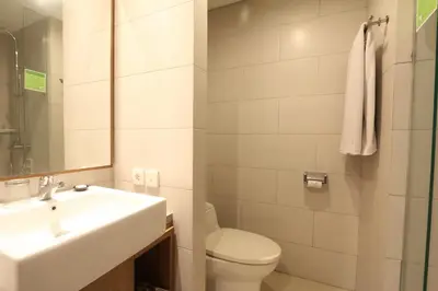 a white bathroom with a sink and a toilet at Grand La Walon Hotel in Legian