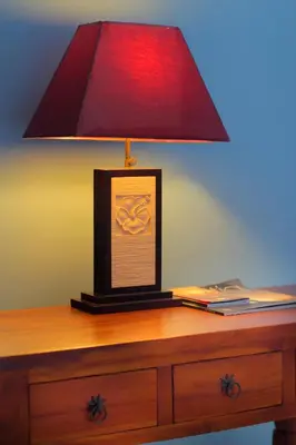 a red lamp sitting on top of a wooden desk at Benoa Rose Residence One in Nusa Dua