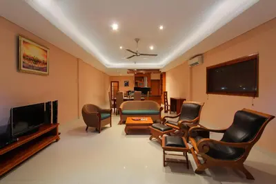 a living room with chairs and a television at Benoa Rose Residence One in Nusa Dua
