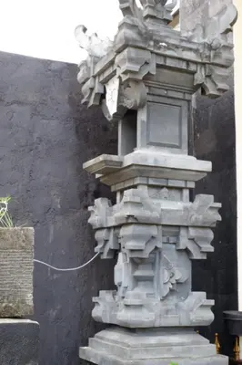 a stone pillar with a light on the side of a building at Akatara Stay in Jimbaran