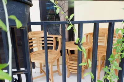 a group of chairs and tables on a balcony at Akatara Stay in Jimbaran